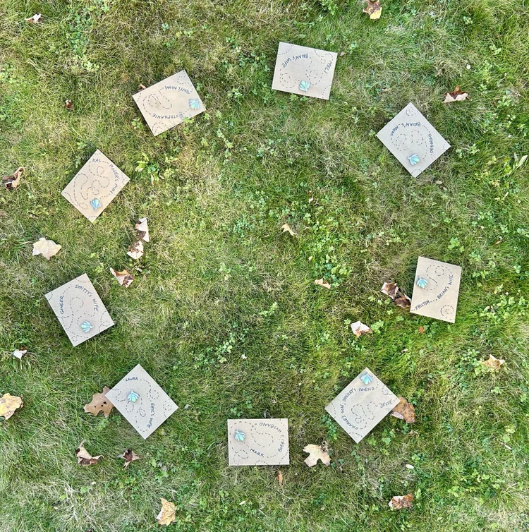 Handmade cards laid on the grass in a circle, each honoring a loved one by name