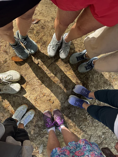 A circle of walkers' shoes gathered on the trail